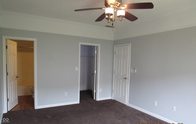 3908 Roundwood Dr, Indianapolis, IN 46235 - unfurnished bedroom with a walk in closet, dark carpet, crown molding, baseboards, and a closet