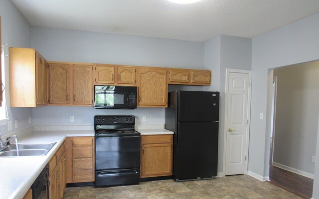 3908 Roundwood Dr, Indianapolis, IN 46235 - kitchen featuring black appliances, a sink, light countertops, and baseboards