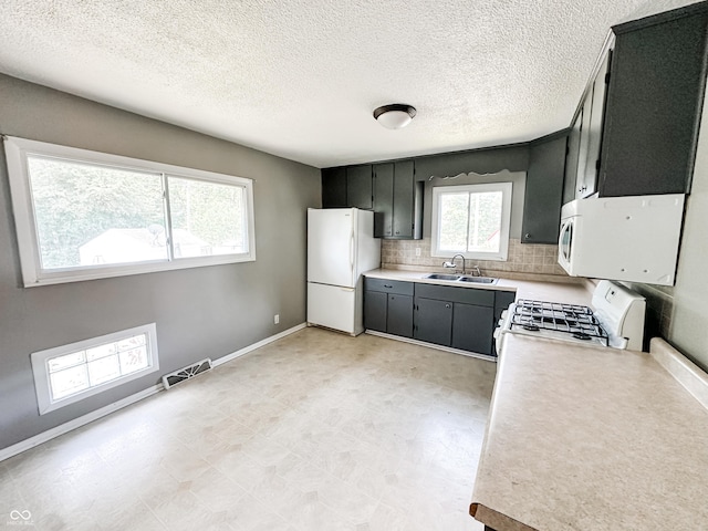 2419 Tamarack Pl, Anderson, IN 46011 - kitchen featuring white appliances, a sink, light countertops, dark cabinetry, and tasteful backsplash