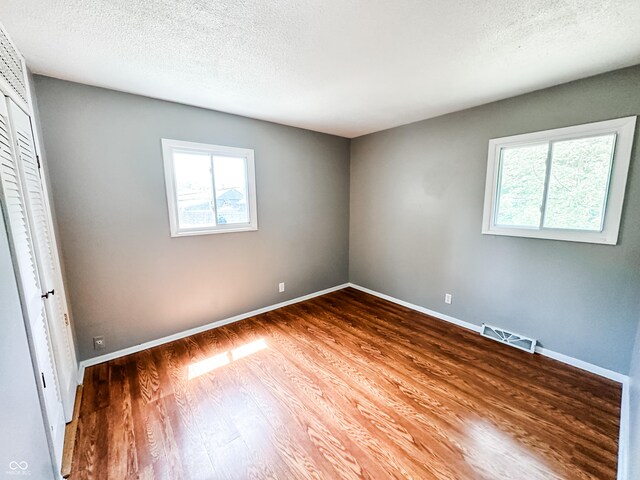2419 Tamarack Pl, Anderson, IN 46011 - unfurnished bedroom with wood finished floors, baseboards, and a textured ceiling