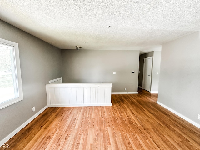 2419 Tamarack Pl, Anderson, IN 46011 - spare room featuring light wood finished floors, a textured ceiling, and baseboards