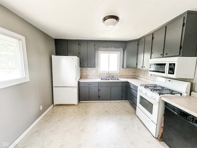 2419 Tamarack Pl, Anderson, IN 46011 - kitchen featuring white appliances, a sink, a textured ceiling, decorative backsplash, and light countertops