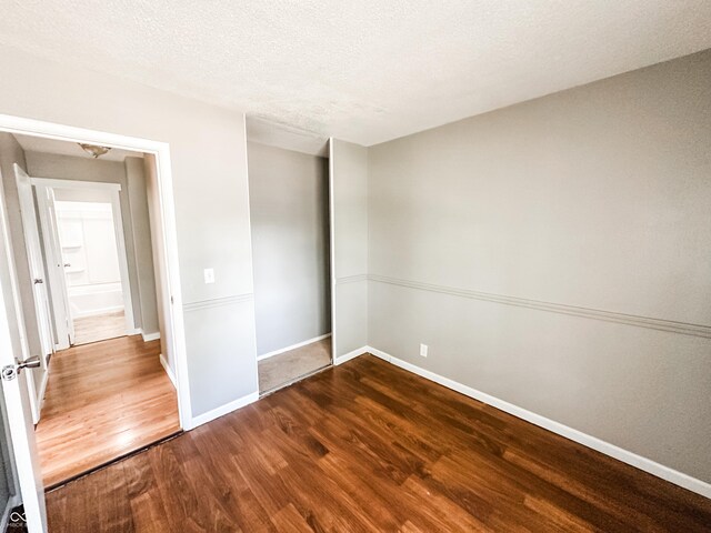 2419 Tamarack Pl, Anderson, IN 46011 - unfurnished bedroom with wood finished floors, baseboards, and a textured ceiling