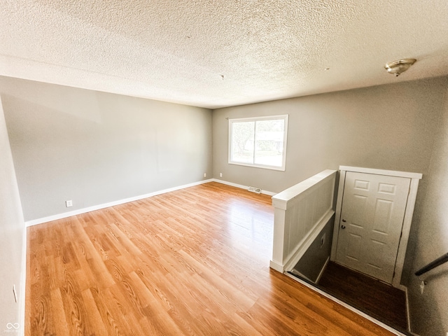 2419 Tamarack Pl, Anderson, IN 46011 - empty room featuring wood finished floors, a textured ceiling, and baseboards