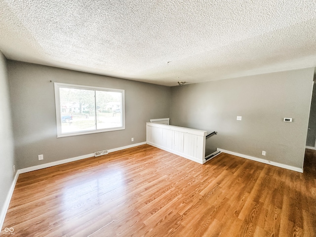 2419 Tamarack Pl, Anderson, IN 46011 - empty room with light wood-style flooring, a textured ceiling, and baseboards