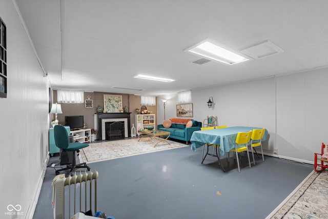 2021 Chestnut St, Columbus, IN 47201 - living area featuring radiator, concrete floors, a brick fireplace, and baseboards