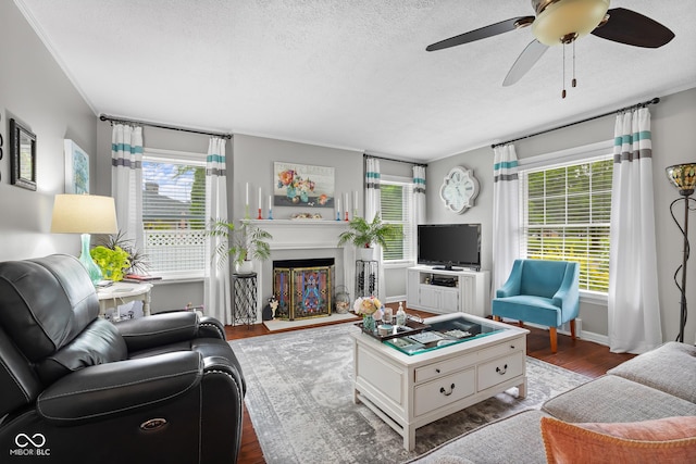 2021 Chestnut St, Columbus, IN 47201 - living area featuring wood finished floors, a ceiling fan, a textured ceiling, a glass covered fireplace, and baseboards