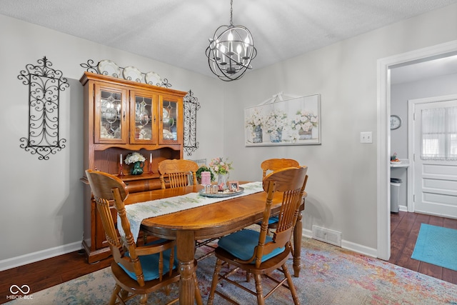 2021 Chestnut St, Columbus, IN 47201 - dining room featuring wood finished floors, a chandelier, baseboards, and a textured ceiling