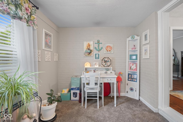 2021 Chestnut St, Columbus, IN 47201 - carpeted bedroom with a textured ceiling, brick wall, and baseboards