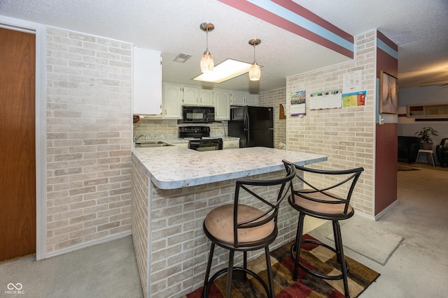 1602 Queensbridge Sq Unit 7, Indianapolis, IN 46219 - kitchen with black appliances, light countertops, a peninsula, a kitchen breakfast bar, and baseboards