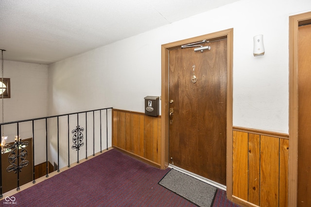1602 Queensbridge Sq Unit 7, Indianapolis, IN 46219 - corridor featuring a wainscoted wall, wooden walls, carpet, and a chandelier