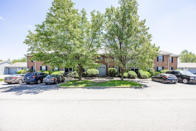 1602 Queensbridge Sq Unit 7, Indianapolis, IN 46219 - view of front of house featuring brick siding and uncovered parking