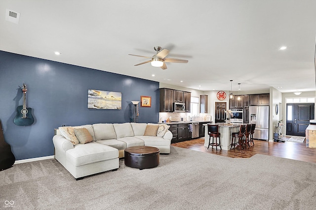 living area featuring dark colored carpet, ceiling fan, plenty of natural light, recessed lighting, and baseboards