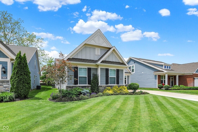 craftsman-style house with board and batten siding, a front yard, and stone siding