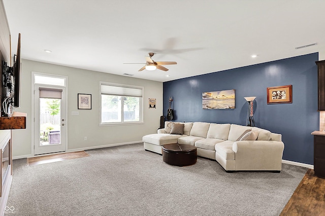 carpeted living room featuring a ceiling fan, baseboards, wood finished floors, and recessed lighting