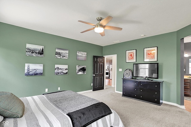 bedroom featuring carpet floors, baseboards, ceiling fan, and connected bathroom