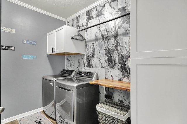 washroom featuring cabinet space, ornamental molding, washer and dryer, and baseboards