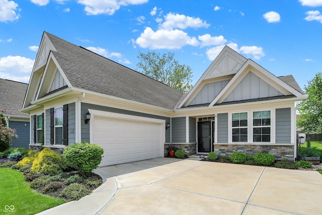 craftsman house with board and batten siding, concrete driveway, a shingled roof, and stone siding