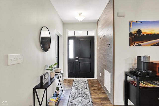 foyer with dark wood-style floors and baseboards