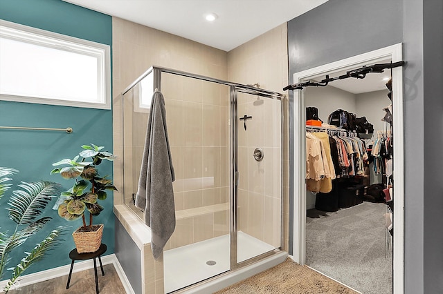 bathroom with a shower stall and a spacious closet