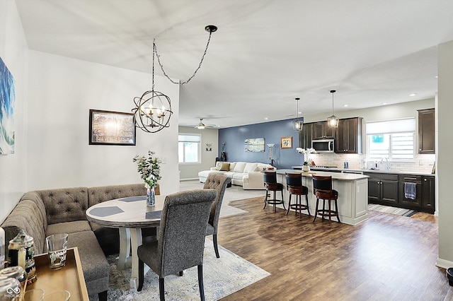 dining space with healthy amount of natural light, ceiling fan, wood finished floors, recessed lighting, and a chandelier