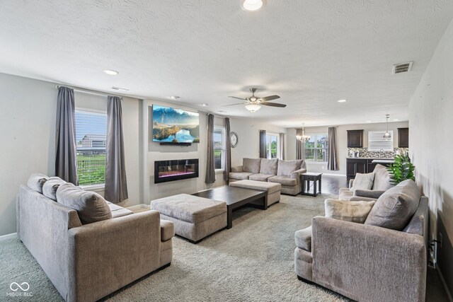 220 Sawdust Trl, Greenfield, IN 46140 - carpeted living area featuring a glass covered fireplace, recessed lighting, ceiling fan, and a textured ceiling