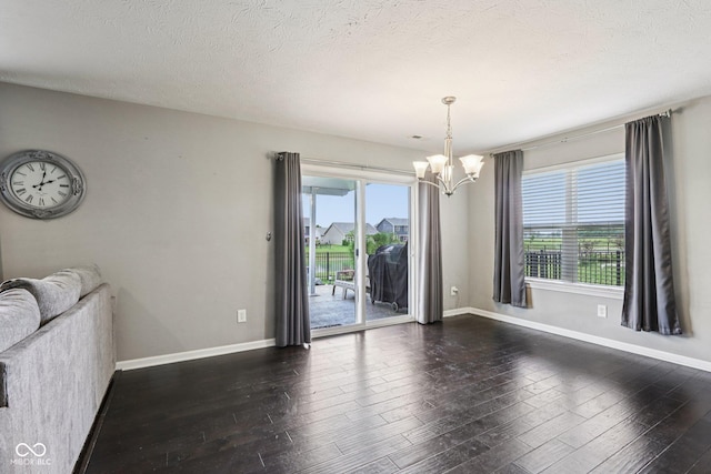 220 Sawdust Trl, Greenfield, IN 46140 - unfurnished living room with a chandelier, dark wood-style floors, and a textured ceiling