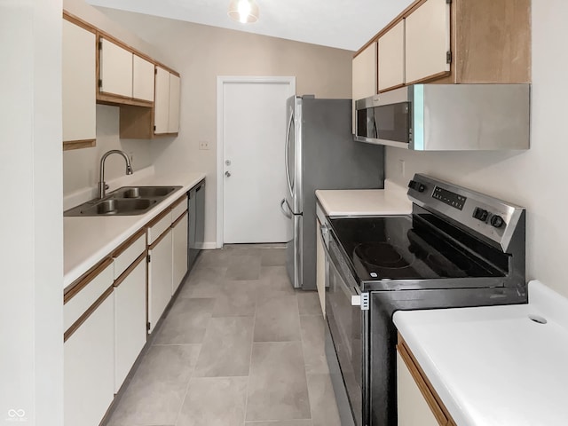 kitchen featuring stainless steel appliances, a sink, and light countertops