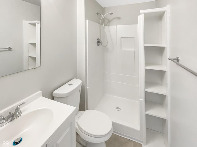 full bath featuring a stall shower, toilet, vanity, and tile patterned floors