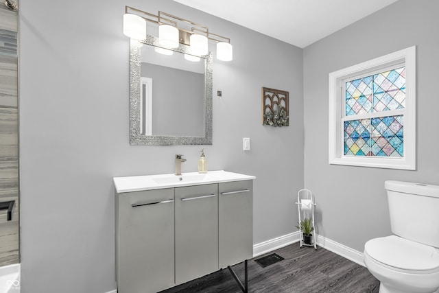 353 S Indiana St, Danville, IN 46122 - bathroom with baseboards, toilet, vanity, and wood finished floors