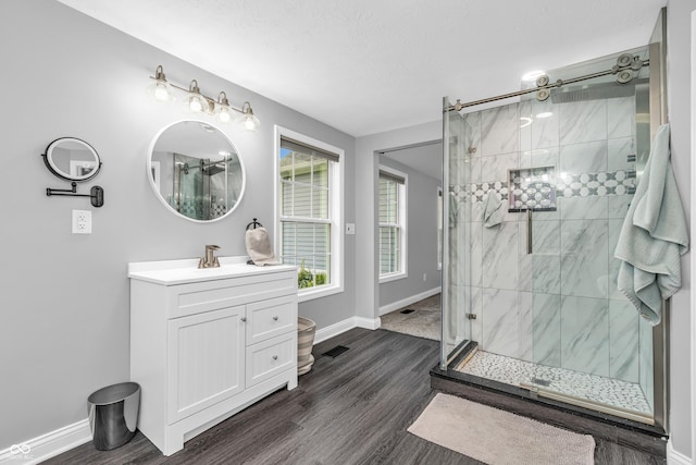 353 S Indiana St, Danville, IN 46122 - full bathroom featuring a shower stall, vanity, wood finished floors, baseboards, and a textured ceiling
