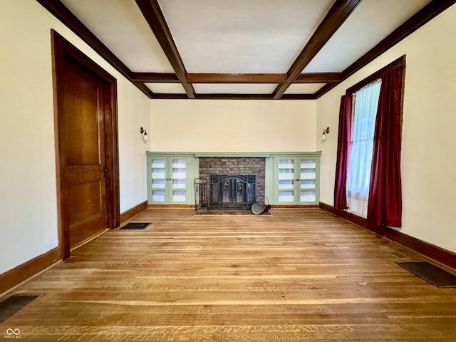 308 W Walnut St, Brownstown, IN 47220 - unfurnished living room featuring coffered ceiling, healthy amount of natural light, baseboards, a brick fireplace, and wood finished floors