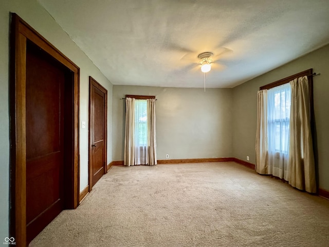 308 W Walnut St, Brownstown, IN 47220 - unfurnished bedroom featuring multiple windows, light carpet, and baseboards