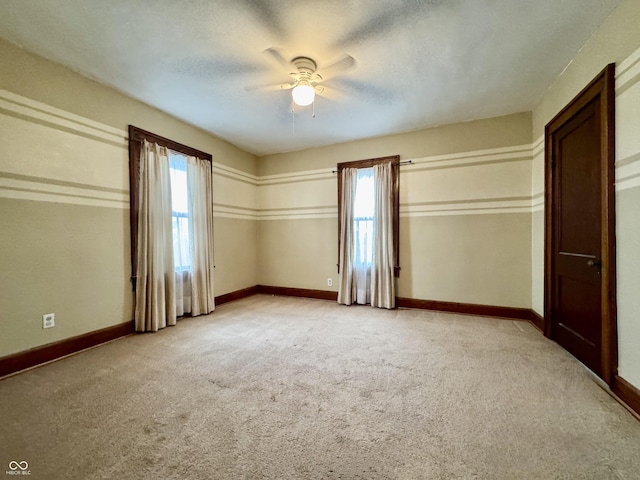 308 W Walnut St, Brownstown, IN 47220 - unfurnished bedroom featuring baseboards, light carpet, and a ceiling fan