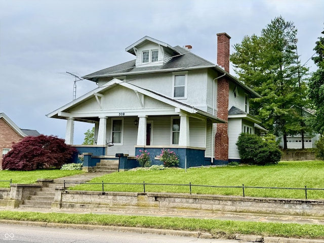 308 W Walnut St, Brownstown, IN 47220 - traditional style home with a chimney, a porch, stucco siding, and roof with shingles