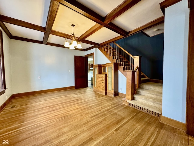 308 W Walnut St, Brownstown, IN 47220 - unfurnished living room with baseboards, coffered ceiling, stairs, a chandelier, and beamed ceiling