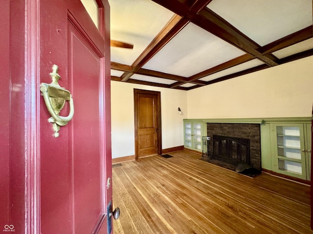 308 W Walnut St, Brownstown, IN 47220 - unfurnished living room featuring coffered ceiling, baseboards, wood finished floors, beam ceiling, and a brick fireplace