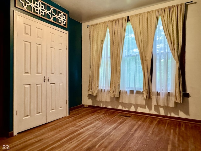 308 W Walnut St, Brownstown, IN 47220 - unfurnished bedroom with baseboards, wood finished floors, and a closet