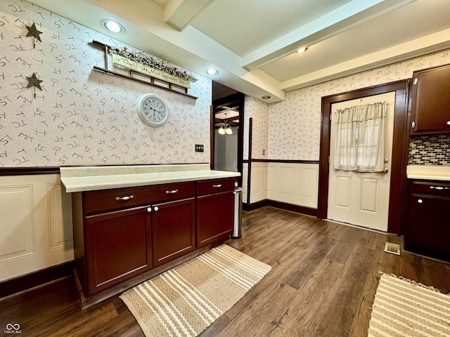 308 W Walnut St, Brownstown, IN 47220 - kitchen featuring wallpapered walls, beam ceiling, light countertops, wainscoting, and dark wood-type flooring