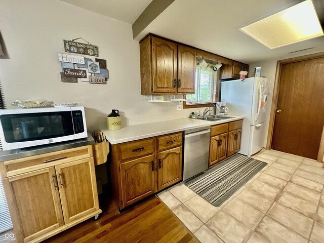 1154 W US Highway 136, Veedersburg, IN 47987 - kitchen with dishwasher, a sink, brown cabinetry, and freestanding refrigerator