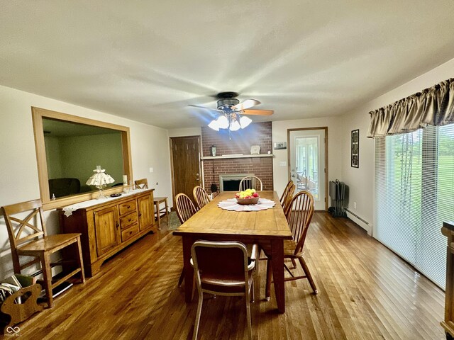 1154 W US Highway 136, Veedersburg, IN 47987 - dining space featuring ceiling fan, dark wood finished floors, a fireplace, and baseboard heating
