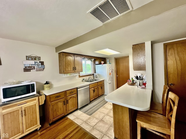 1154 W US Highway 136, Veedersburg, IN 47987 - kitchen with white appliances, a sink, light countertops, and brown cabinetry