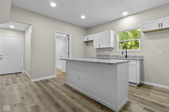 418 Harlan St, Indianapolis, IN 46201 - kitchen featuring white cabinets, light stone countertops, baseboards, light wood-style flooring, and recessed lighting