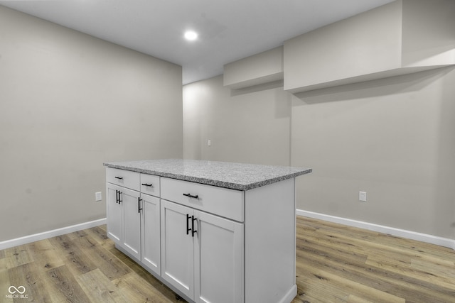 418 Harlan St, Indianapolis, IN 46201 - kitchen featuring light wood-type flooring, white cabinets, baseboards, light stone counters, and recessed lighting