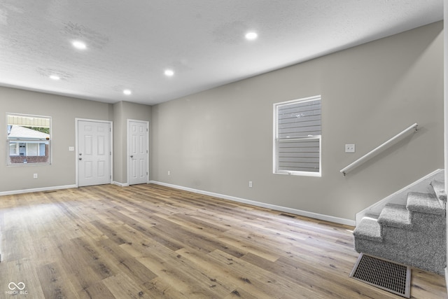 418 Harlan St, Indianapolis, IN 46201 - unfurnished living room featuring recessed lighting, wood finished floors, baseboards, and stairs