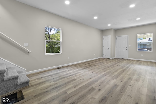418 Harlan St, Indianapolis, IN 46201 - unfurnished living room featuring recessed lighting, plenty of natural light, stairway, baseboards, and light wood-style flooring