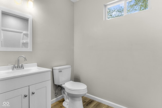 418 Harlan St, Indianapolis, IN 46201 - bathroom featuring wood finished floors, baseboards, toilet, and vanity