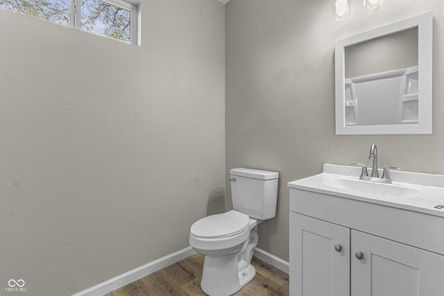 418 Harlan St, Indianapolis, IN 46201 - bathroom featuring wood finished floors, baseboards, vanity, and toilet