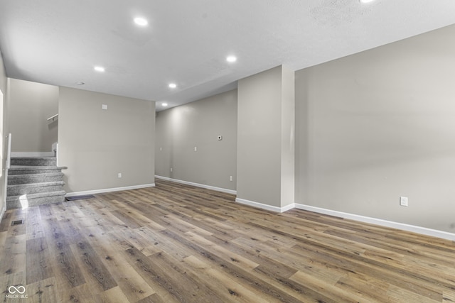 418 Harlan St, Indianapolis, IN 46201 - unfurnished living room with wood finished floors, baseboards, stairs, and recessed lighting