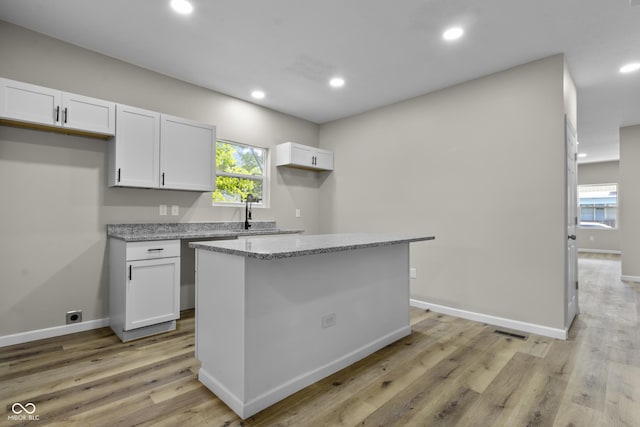 418 Harlan St, Indianapolis, IN 46201 - kitchen featuring white cabinetry, healthy amount of natural light, recessed lighting, light wood-style flooring, and light stone countertops